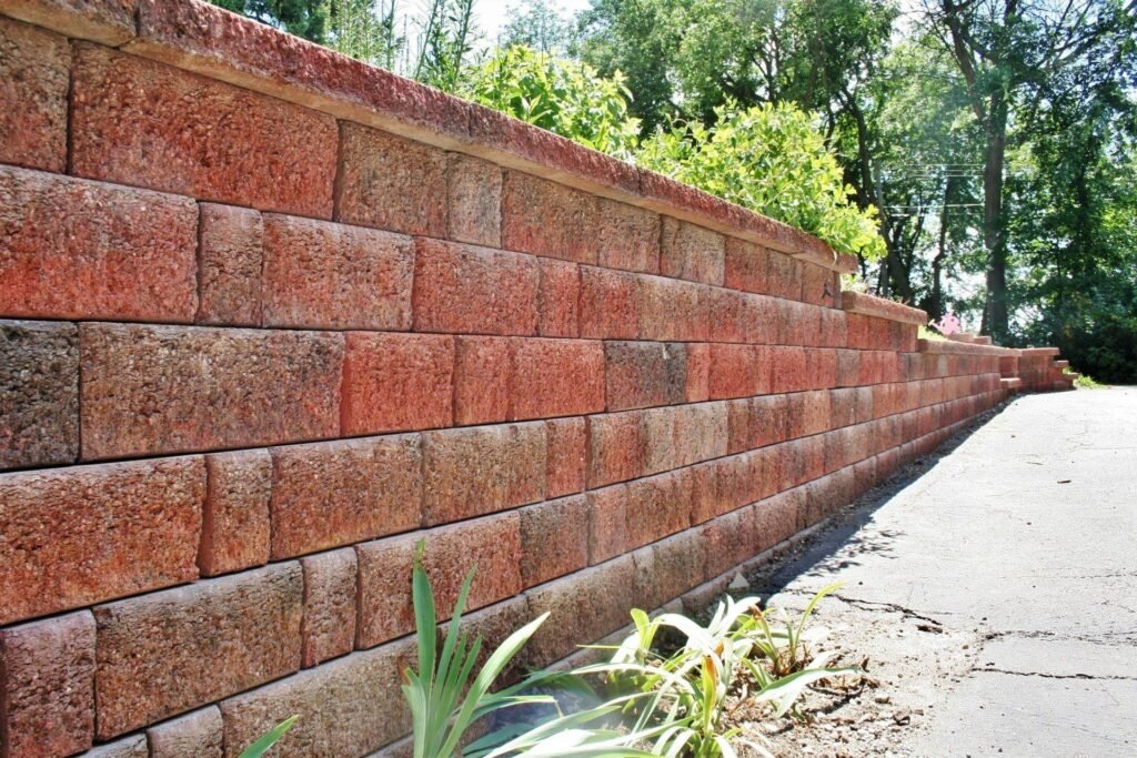 Red segmental block retaining wall along a driveway in Ann Arbor, MI