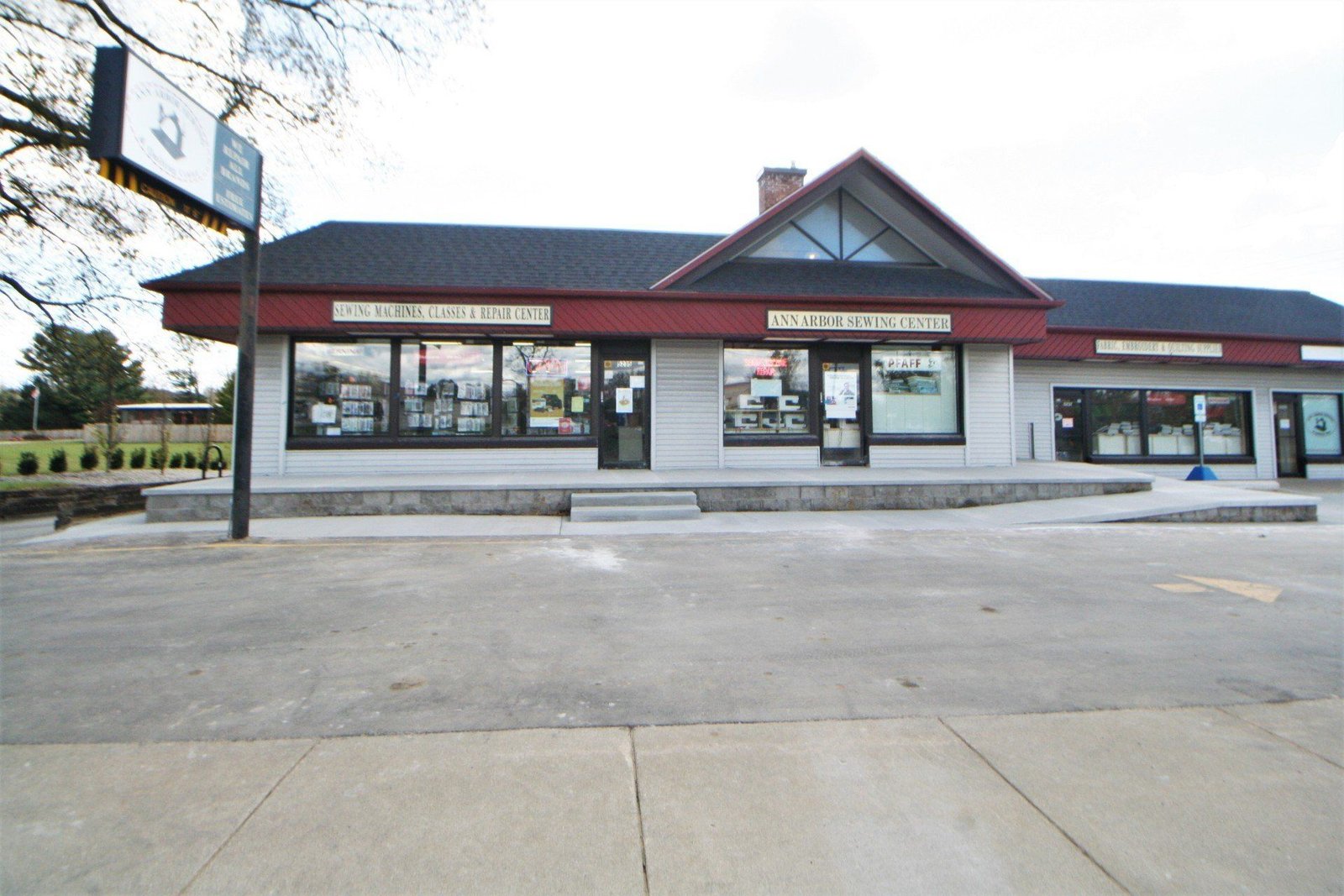 Small commercial strip mall with red trim across an empty parking lot