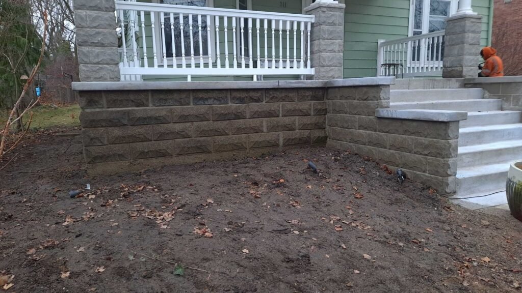 Block retaining wall beside a porch in a backyard in Ann Arbor, MI