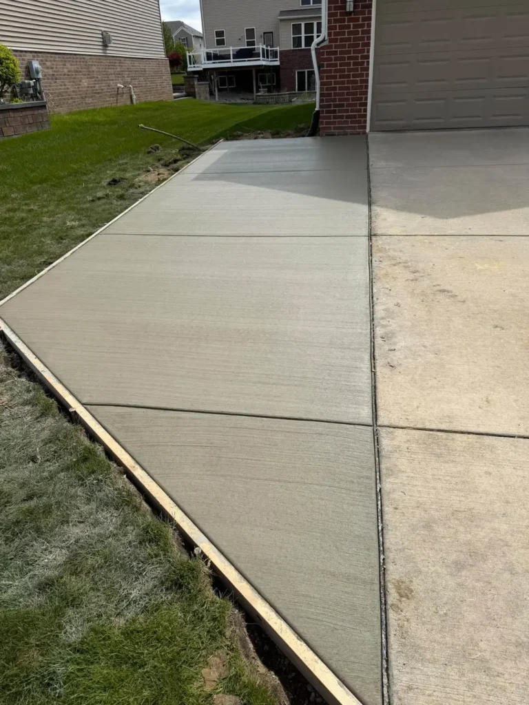 Concrete driveway extension poured beside a garage in Ann Arbor, Michigan