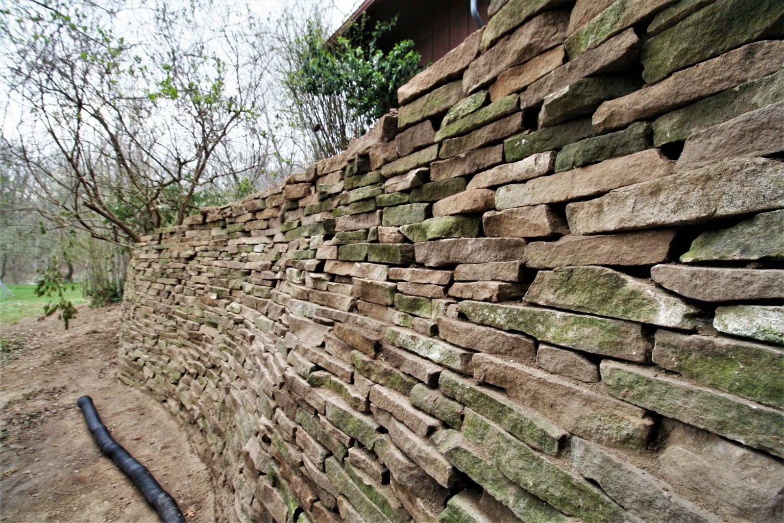 Close-up of a dry-stack stone retaining wall showing individually stacked flat stones