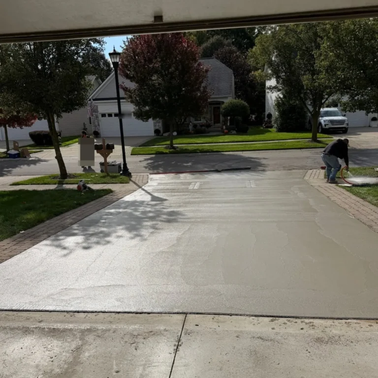 Freshly finished concrete driveway curing with control joints in Ann Arbor Hills, MI